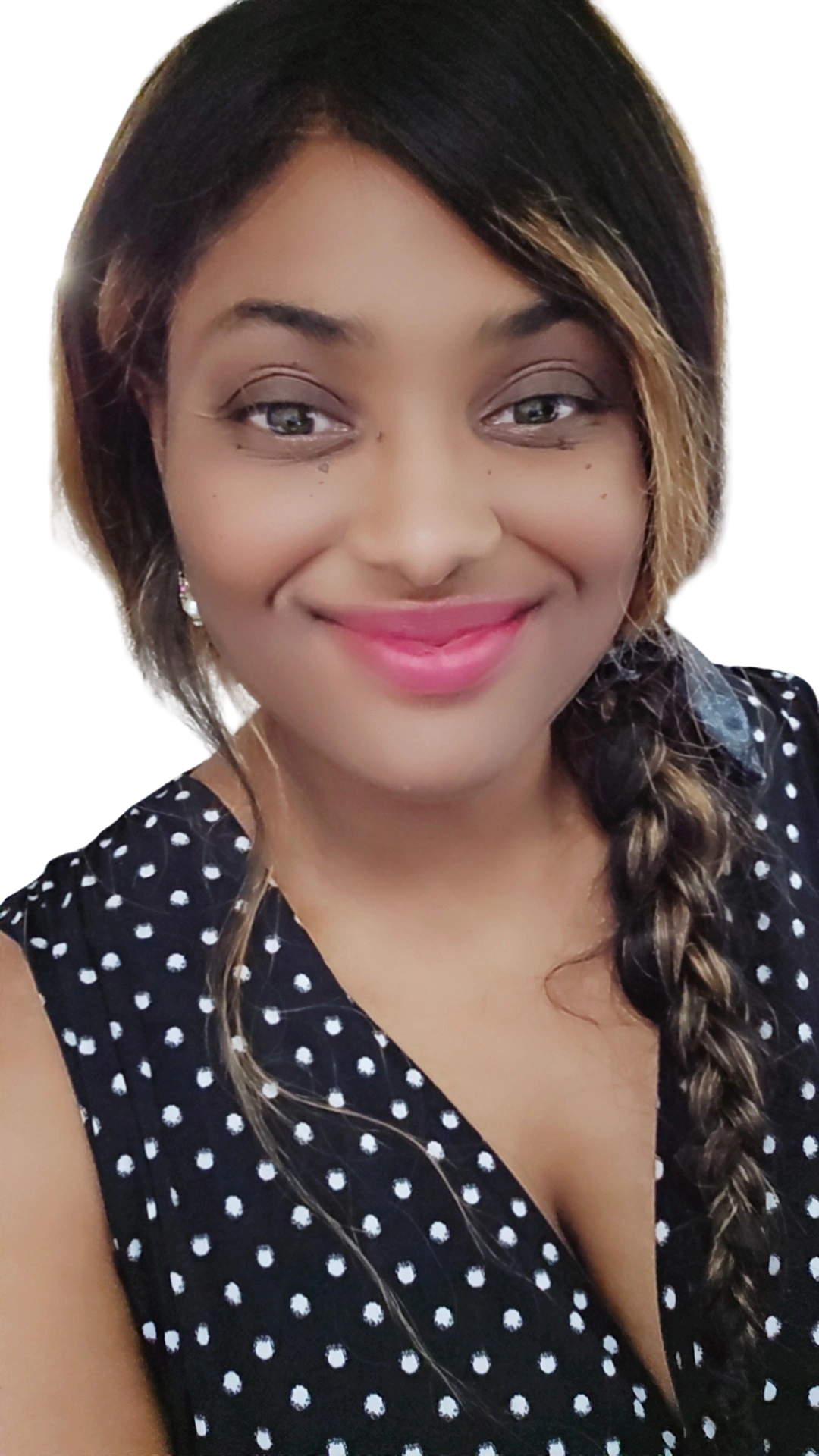 Smiling woman with braided hair in a black polka dot dress.