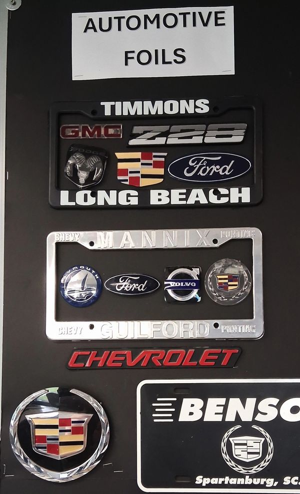 Display of automotive foil badge frames and emblems.