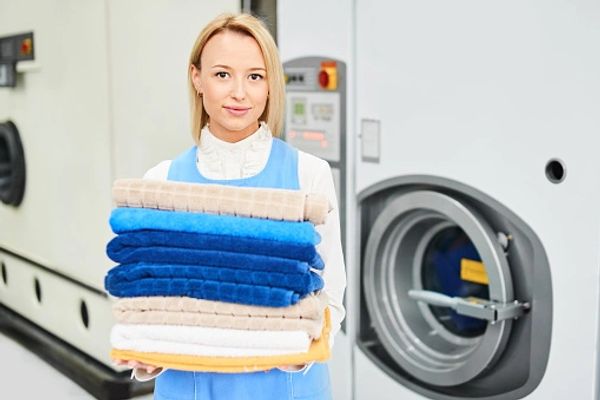 Portrait of a girl Laundry worker holding a clean towel to dry