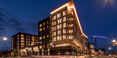Modern apartment buildings lit up at night.
