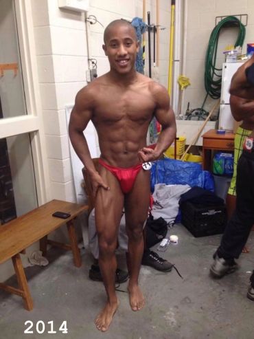 A young male bodybuilder posing in a locker room in 2014.