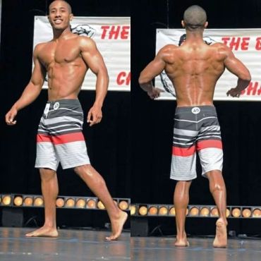 Man showing off muscular physique on stage.