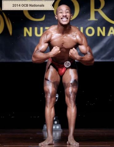 Bodybuilder flexing muscles at 2014 OCB Nationals.