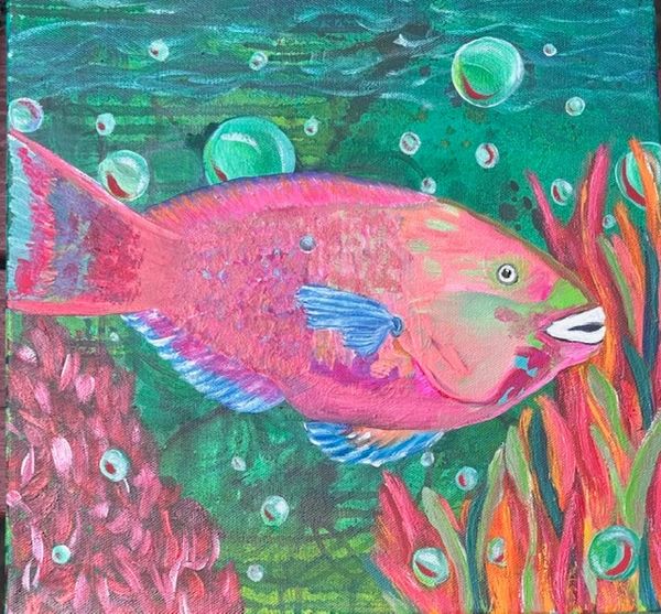 Colorful pink fish swimming among underwater plants and bubbles.