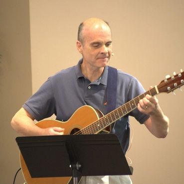Brian Morris performing on acoustic guitar with vocals.
