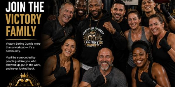 Group of diverse, smiling people at Victory Boxing Gym promoting community and fitness.