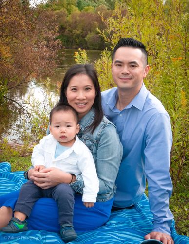 Family portrait by the lake with autumn foliage.