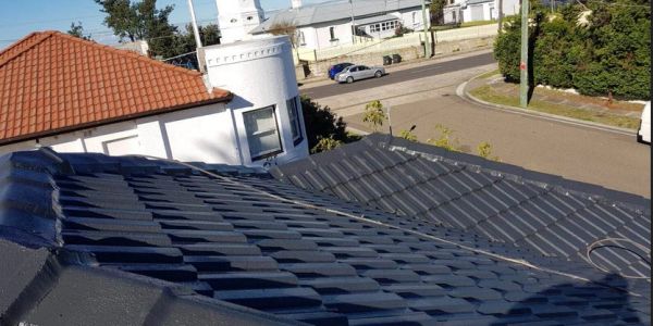View of rooftops with different colored tiles under clear sky.