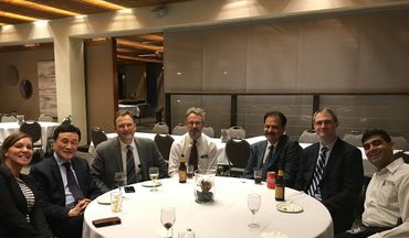 A group of professionals sitting around a round table in a formal setting.
