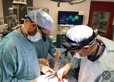 Two surgeons perform a delicate operation in a well-equipped operating room.