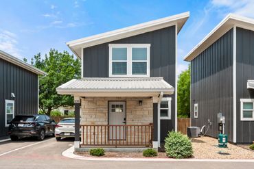 Modern two-story house with dark siding and a small front porch.