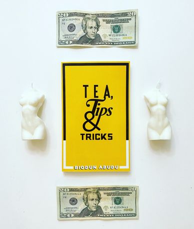 Biodun Abudu's book Tea, Tips & Tricks with 20 dollar bills and female figure body nude candles