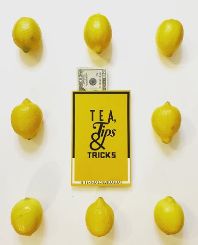 A creative book photoshoot with Biodun Abudu's   Tea,Tips & Tricks with lemons and a 20 dollar bill