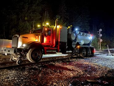 A specialized truck equipped to travel on railway tracks at night.