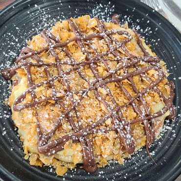 Sweet Tooth Pancake filled and topped with vanilla custard, Nutella chocolate & Ghirardelli caramel.