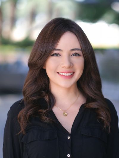 Smiling woman with wavy hair in black shirt.