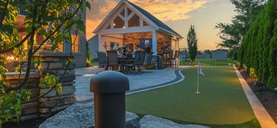 A group enjoying an evening around a table near a putting green.
