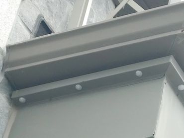 Close-up of a gray metal beam with bolts and rivets.