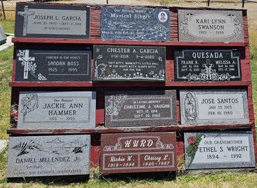 A collection of memorial plaques honoring various individuals with birth and death dates.
