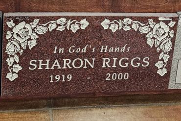 Gravestone plaque for Sharon Riggs, 1919-2000, with floral decorations.