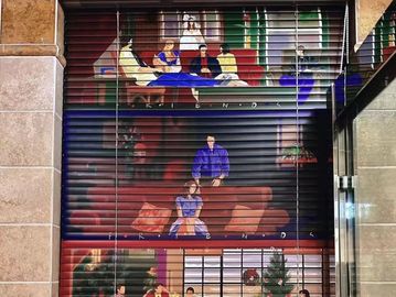 Artistic mural depicting scenes from the TV show 'Friends' on a shutter door.