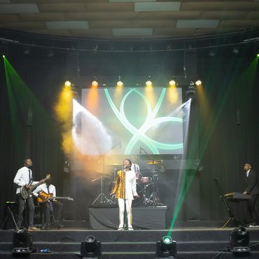 Denise Moyo, poet, singer and songwriter who was born in Zimbabwe singing on stage.