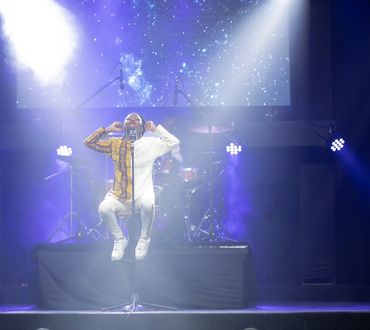 Denise Moyo, poet, singer and songwriter who was born in Zimbabwe singing on stage.