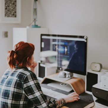 Person working thoughtfully on a computer in a cozy home office.