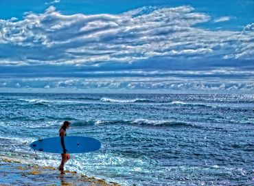 Surfer girl about to hit the waves, Rincon Beach, Puerto Rico.