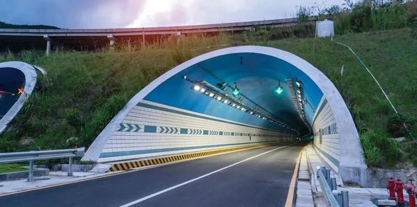 Illuminated highway tunnel entrance.