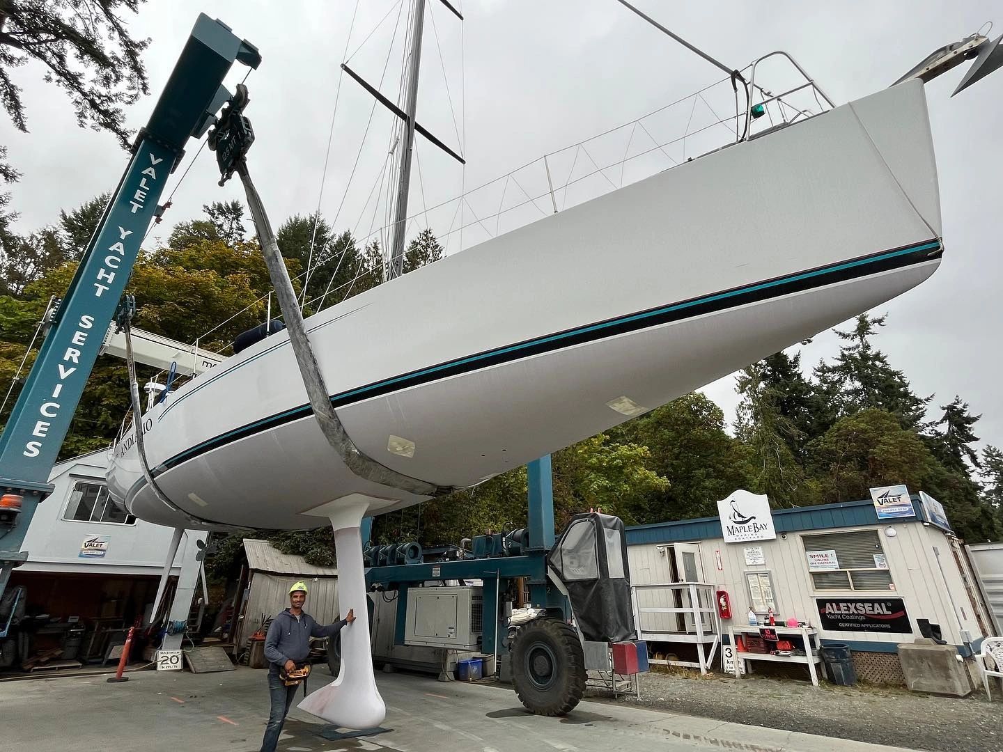 Man standing next to boat on a sling