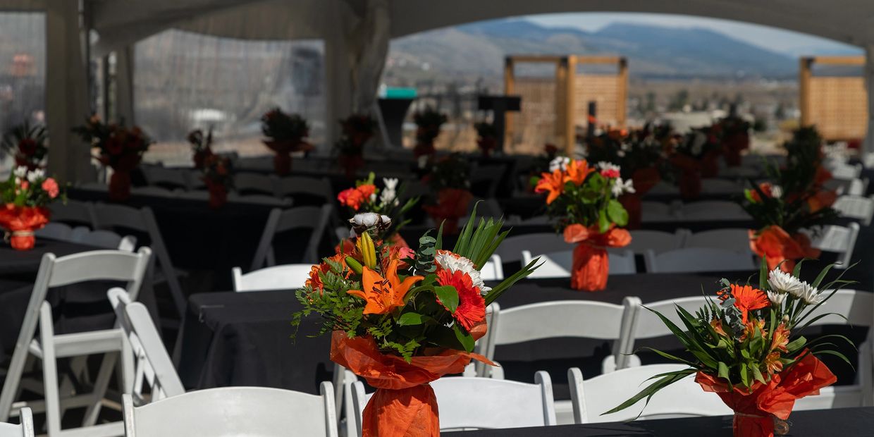 Event table setup with orange flower bouquets