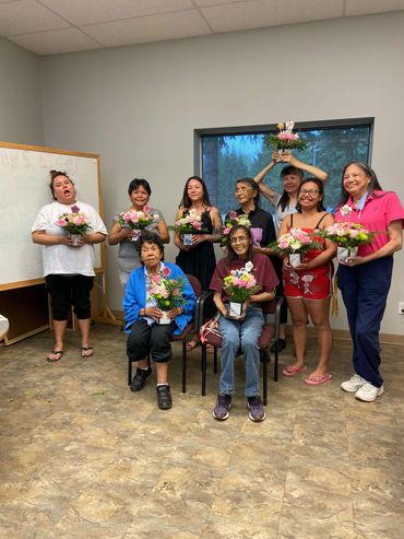 Participants holding flower arrangements they created at therapeutic flower workshop.