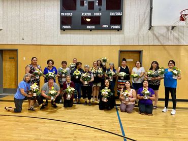 Women holding flower arrangements at therapeutic flower workshop, displaying finished bouquets