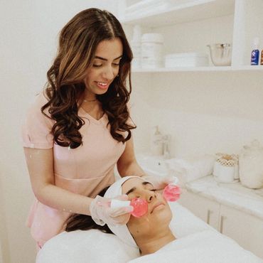 esthetician doing a facial with ice globes for glowing skin