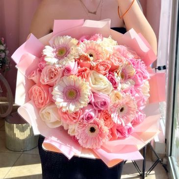 Ramo de flores en tonos rosados y blancos.