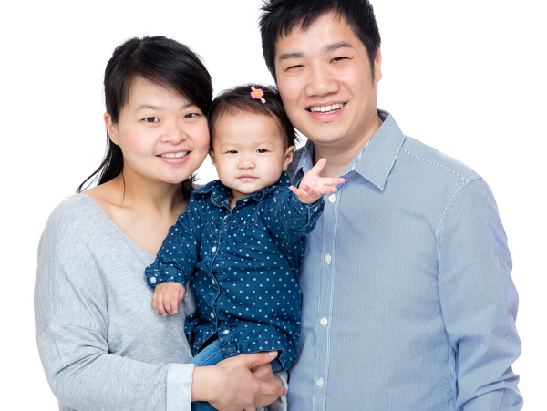 Happy Asian family posing together with their baby on a white background.