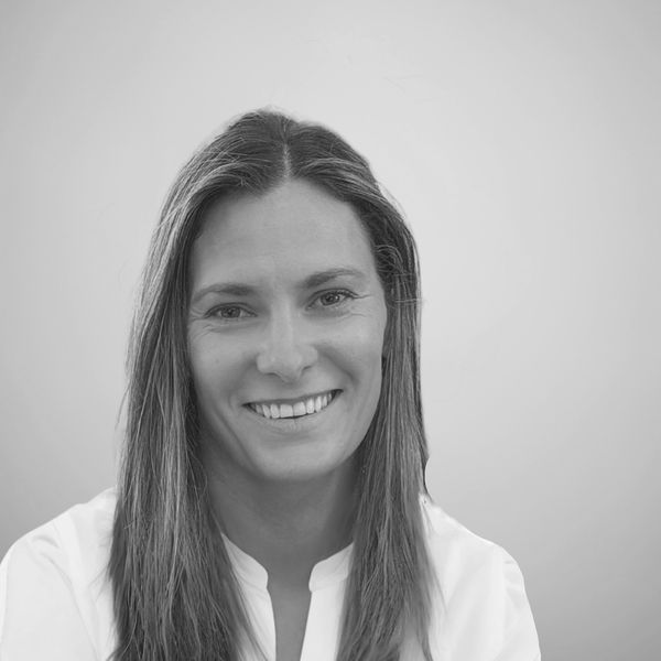 Black and white portrait of a smiling woman with long hair.