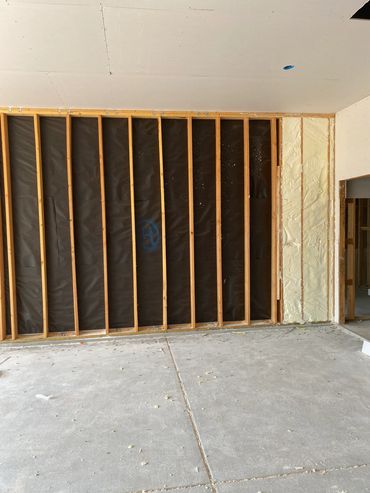 Partially insulated wall framing in a construction site.
