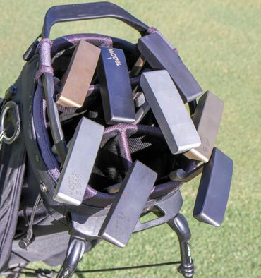milled putters in a golf bag