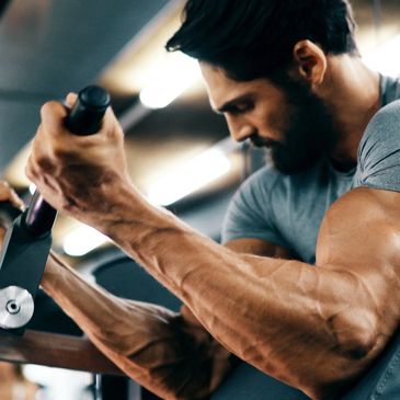 Hombre con barba ejercitándose en el gimnasio para potenciar su energía y vitalidad
