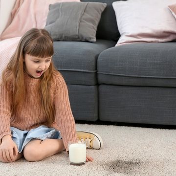 Little girl sitting on a soiled carpet that needs deep carpet cleaning