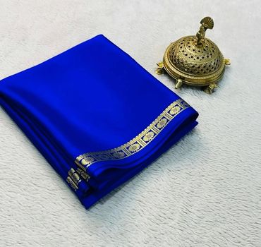Elegant royal blue fabric with gold floral border next to a decorative brass incense holder.