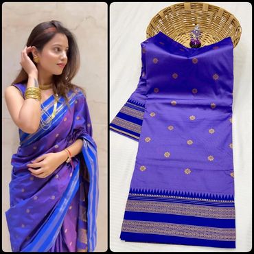 Elegant woman in a royal blue saree with gold motifs and matching folded saree beside her.