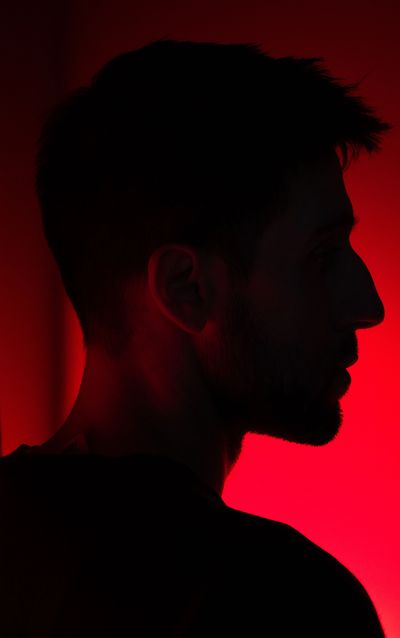 Silhouette of a man's profile with red backlighting.