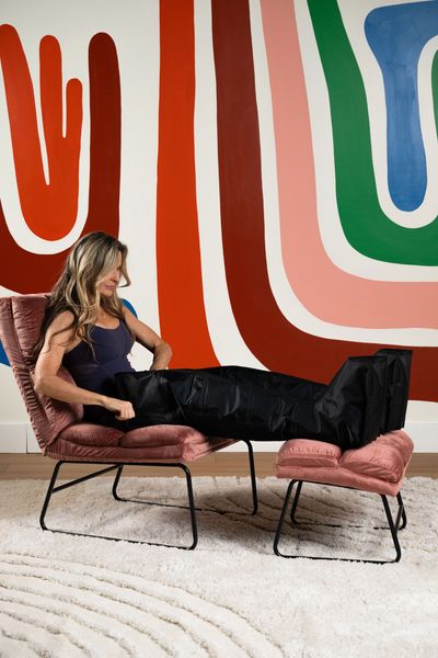 Woman doing compression therapy in front of colourful mural.