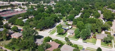 Aerial view of a suburban neighborhood with many trees and houses.