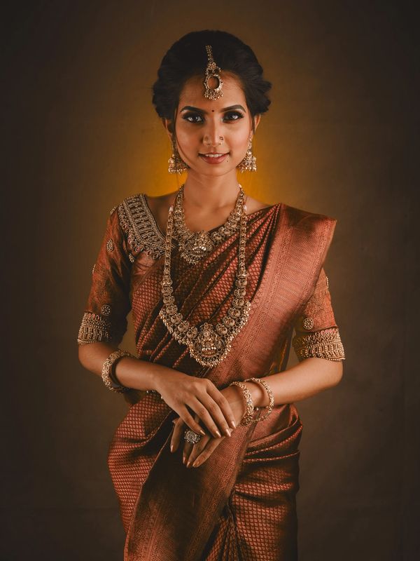 A woman wearing a copper saree