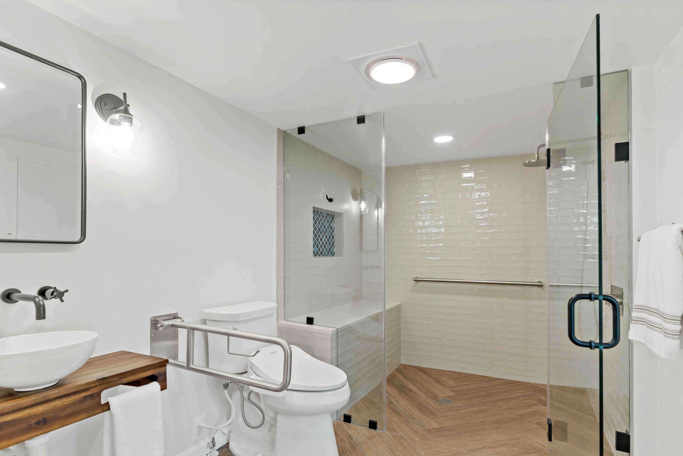 Modern bathroom with walk-in shower and wooden accents.
