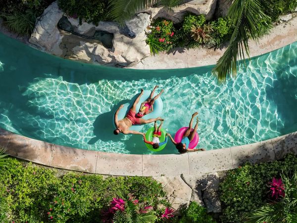 family floating on tubes in the lazy river at beaches Resort